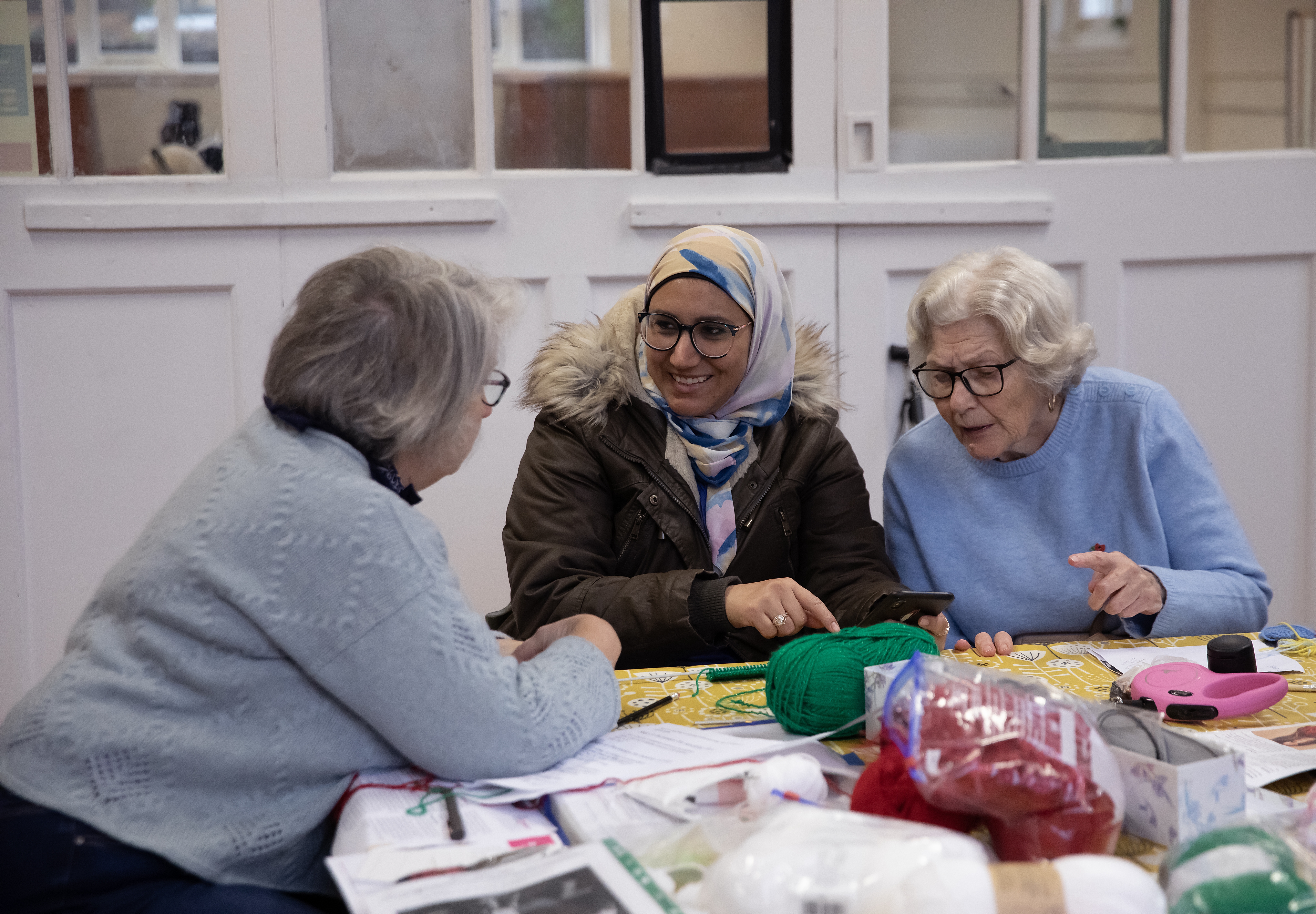Service users at Mortlake Community Association London chat around a crafts table