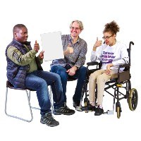 Three people looking at a paper. They are smiling and making the thumbs up sign