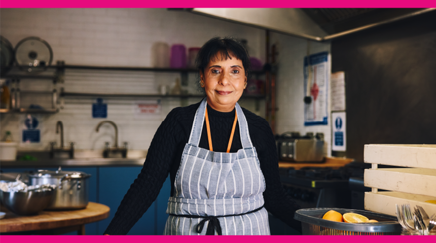 A woman wearing an apron in a community kitchen