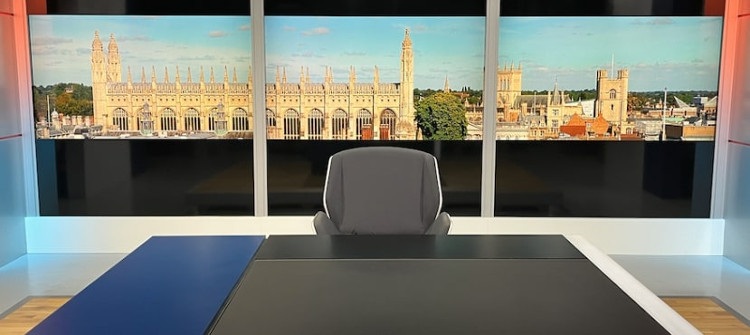 TV news studio with a view over Cambridge behind, showing the University of Cambridge King's College Chapel