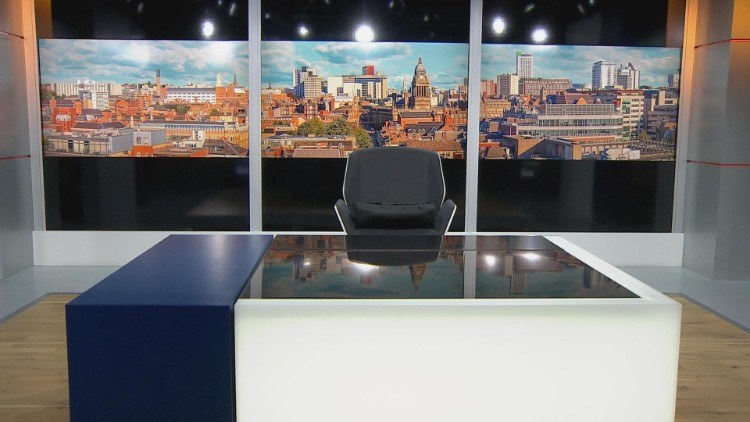 TV news studio with a view over Leeds centred on the clock tower of Leeds Town Hall
