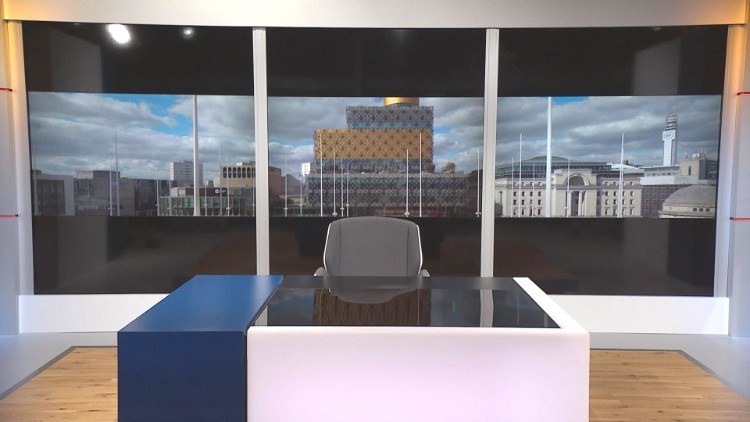 TV news studio with Birmingham skyline behind showing the Library of Birmingham and the BT Tower