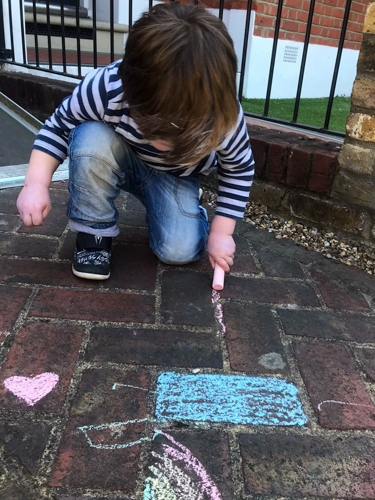 Young child chalking the pavement