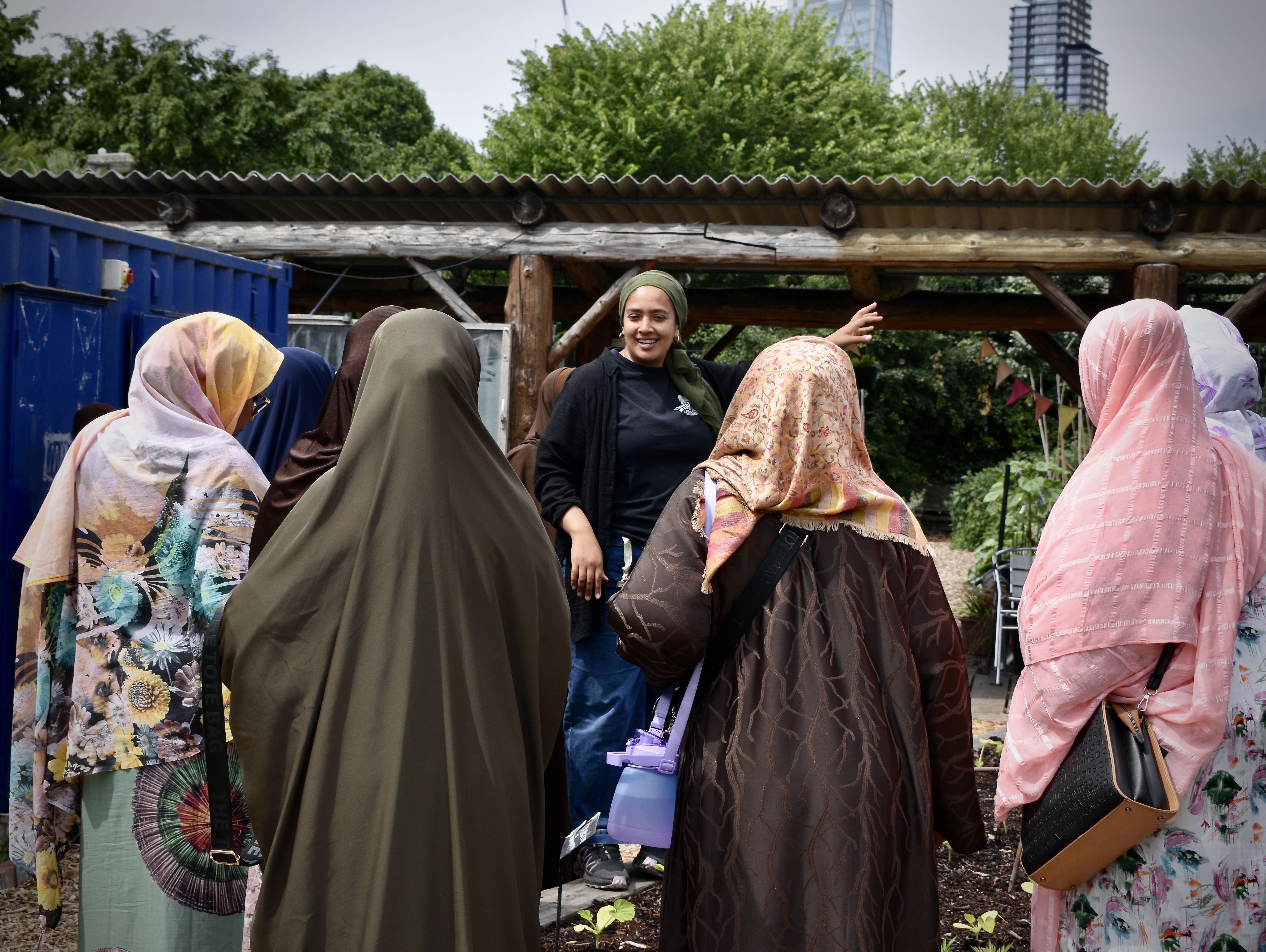 A group of women in a garden space smiling and talking