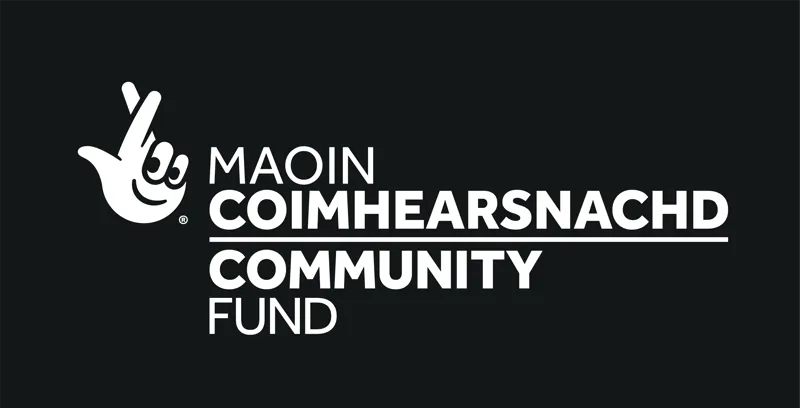 The National Lottery Community Fund white logo black background in Gaelic