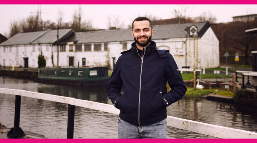 A man standing by a canal 